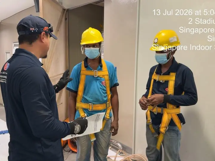 Crew in harnesses getting a pre-entry check before confined-space work in Kallang