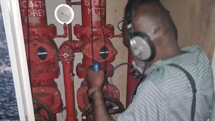 DJR technician using an acoustic leak detector on water riser pipes